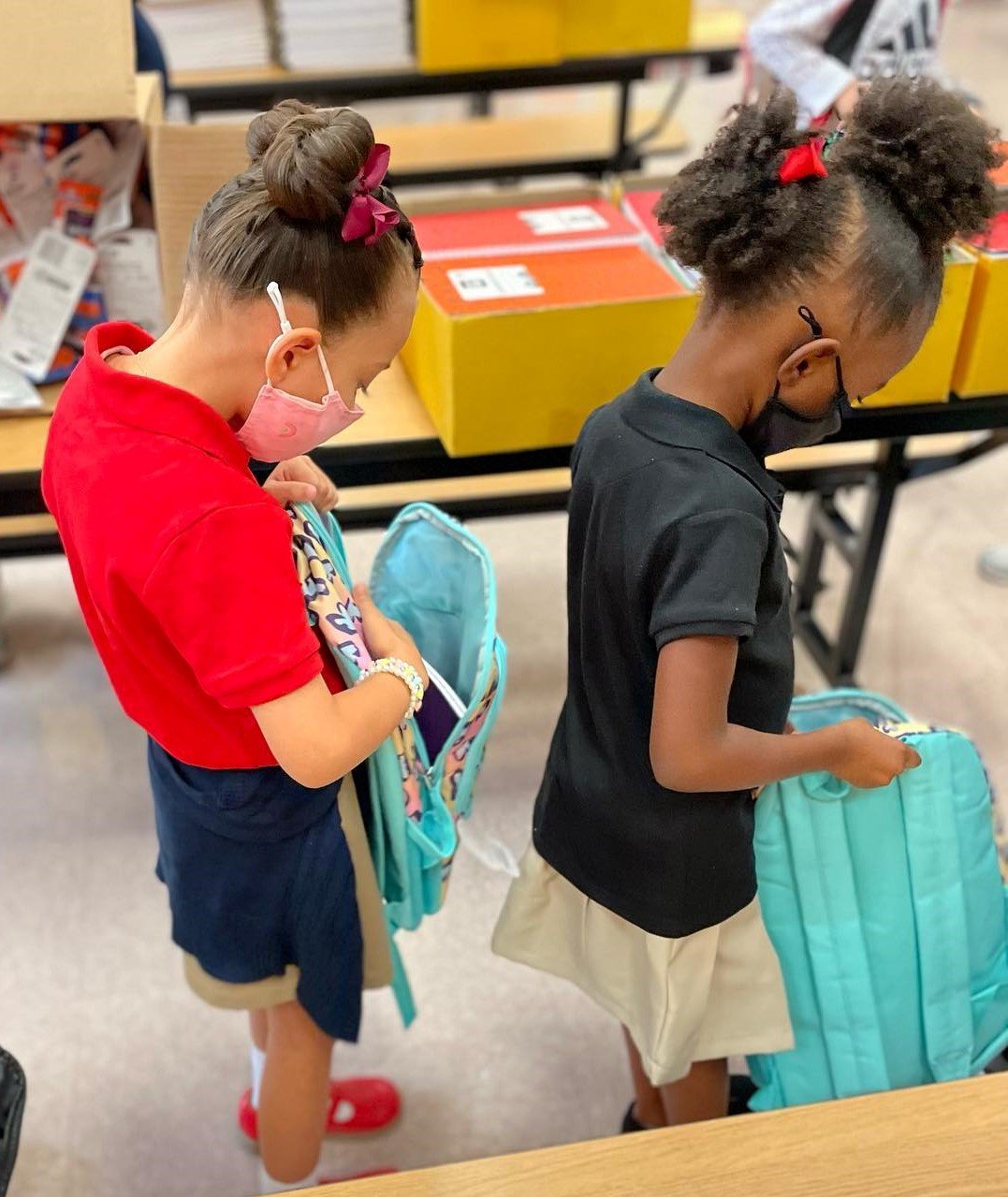 Two students look inside the backpacks given to them by CSI Gives Back.